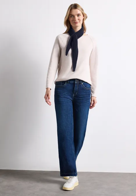 Mini Dreieckstuch in Unifarbe indigo night Frau trägt beigefarbenen Pullover, weite Jeans, weiße Sneakers und losen dunklen Schal vor weißem Hintergrund.