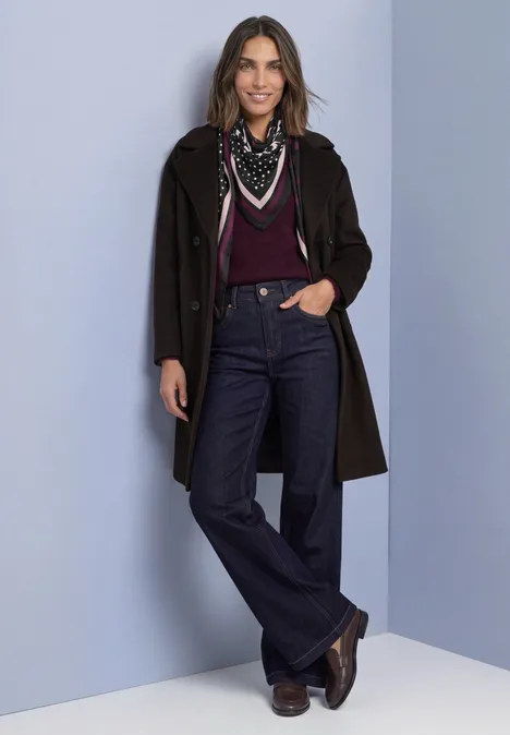 Driehoekige sjaal met gemengde patronen Black Een vrouw in een donkere mantel, bordeauxrode top, jeans, sjaal en laarzen tegen een neutrale achtergrond.