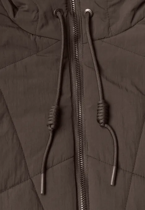 Nahaufnahme einer dunkelbraunen Steppjacke mit Reißverschluss und Kapuzenbändern.