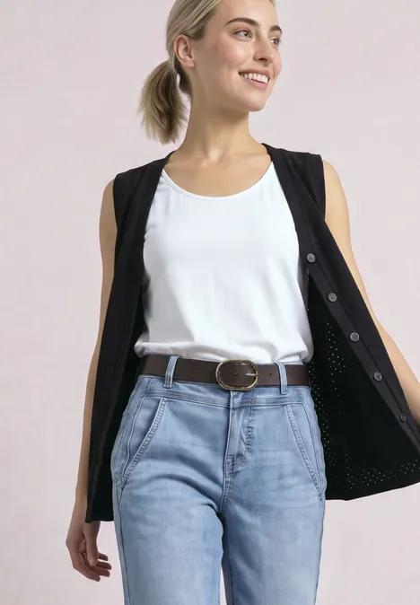 Gürtel mit dekorativer Schnalle auburn brown Lächelnde Frau mit blondem Haar, weißem Tanktop, schwarzer Weste offen, hellblauen Jeans und Gürtel.