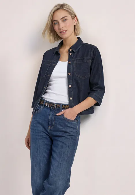 Riem met bont en luipaardprint cognac Eine junge Frau posiert in Jeansjacke, weißem Top und Jeans vor hellem Hintergrund.