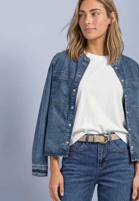 Velours Gürtel mit Nieten barley beige Frau in weißem T-Shirt und Jeans mit lässiger Jeansjacke vor neutralem Hintergrund.
