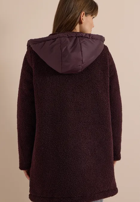 Strukturmix Teddy-Mantel mit Kapuze berry red Eine Person von hinten in einem dunkelvioletten, flauschigen Teddy-Kapuzenmantel.