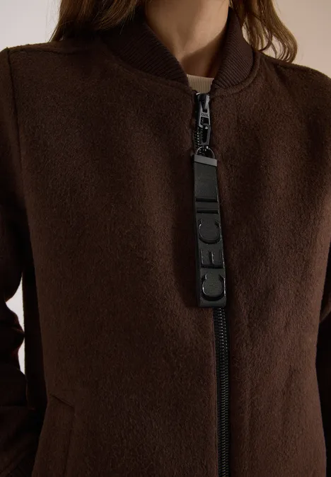 Nahaufnahme einer dunkelbraunen Wolljacke mit Reißverschluss und breitem Zipper-Anhänger.