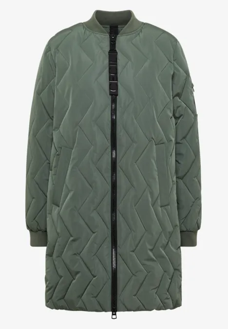 Manteau matelassé long vert olive avec couture en zigzag, fermeture éclair intégrale et poches latérales.