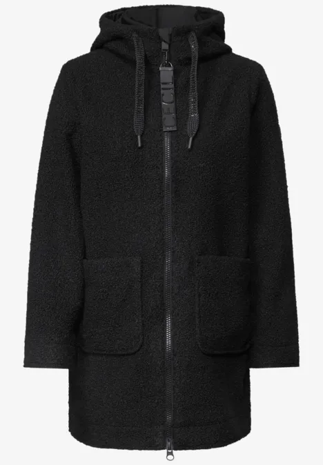 Manteau noir en teddy fleece avec capuche, fermeture éclair et deux poches plaquées.