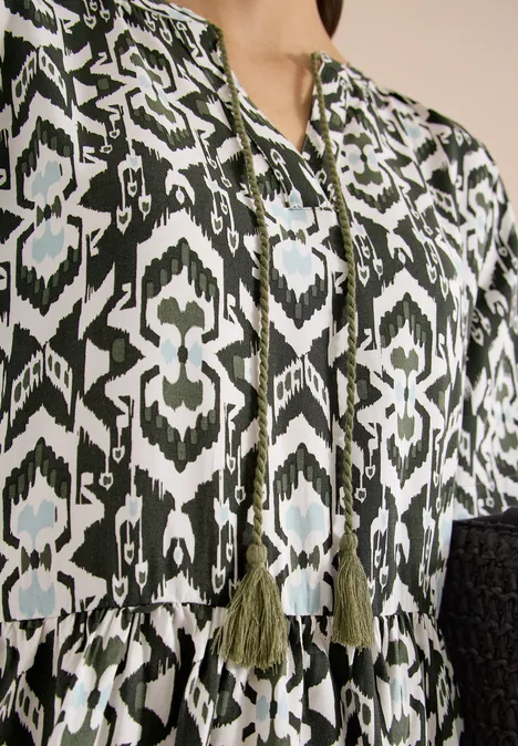 Bluse mit grün-schwarzem ethnischem Muster und Quasten am Ausschnitt