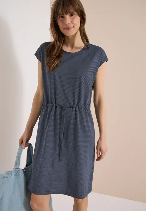 Knielanges Kleid aus Jersey universal blue Frau trägt lässiges kurzes dunkelblaues Kleid mit Taillenschnur und kurzer Schulterpartie, hält Umhängetasche