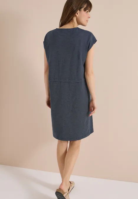 Knielanges Kleid aus Jersey universal blue Rückansicht einer Frau in kurzem Jeanskleid und flachen Sandalen.