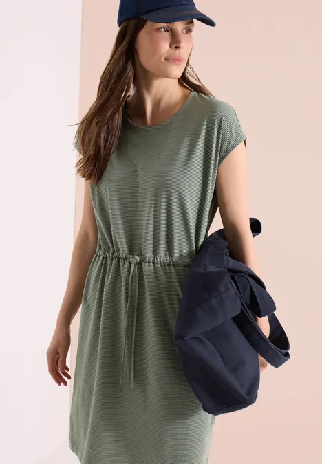 Knielanges Kleid aus Jersey khaki Frau in olivgrünem, kurzärmeligem Kleid mit Taillenschnürung, die eine dunkelblaue Tasche hält.