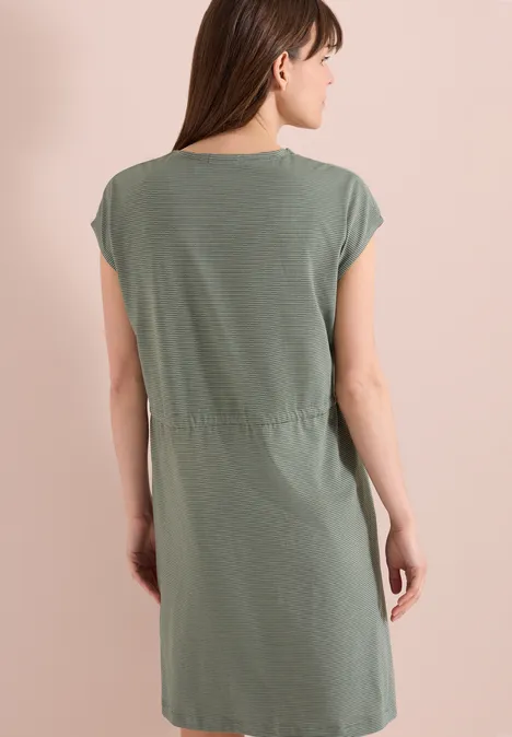 Knielanges Kleid aus Jersey khaki Frau steht mit dem Rücken zur Kamera, trägt grünes kurzärmeliges knielanges Kleid.