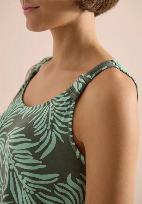 Dunkelgrünes Damen-Top mit hellem Blattmuster und weitem Rundhalsausschnitt, sportlich-elegant.