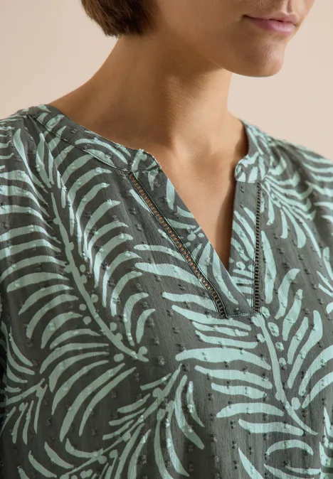 Midikleid mit Split Neck und Print khaki Frau mit grünem Oberteil im Blattmuster und V-Ausschnitt.