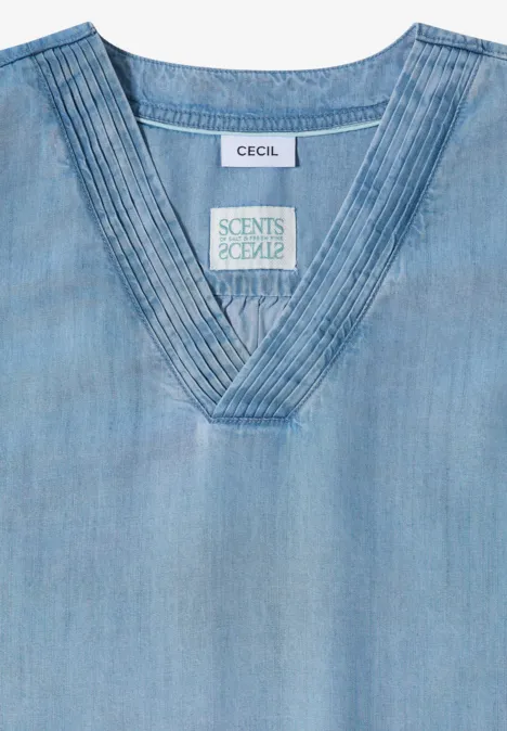 Lichtblauw denim topje met V-hals en fijne stiksels langs de kraag.