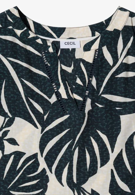 Top noir à motif de grandes feuilles de monstera blanches et encolure fendue discrète.