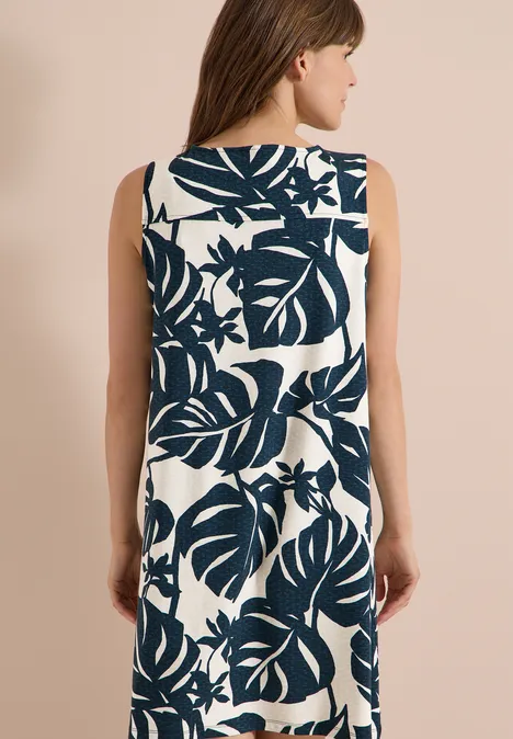 Knielanges Jerseykleid mit V-Neckund Print palm breeze green Frau von hinten im ärmellosen, weißen Kleid mit dunkelblauem, tropischem Blattmuster.