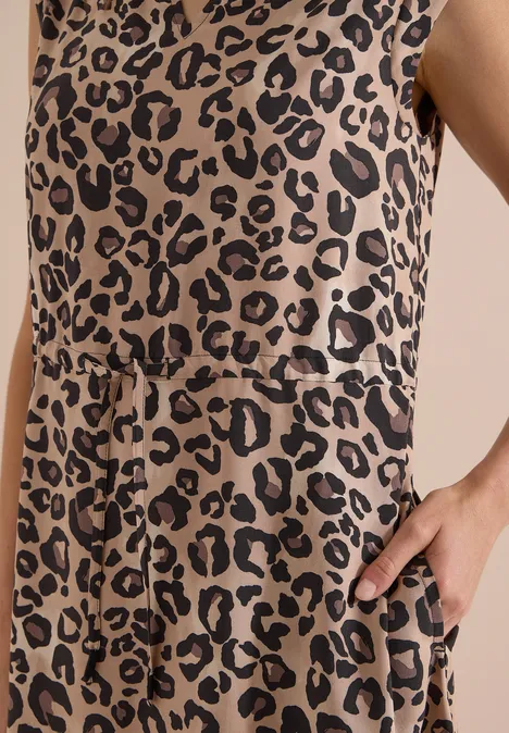 Nahaufnahme eines ärmellosen Kleides mit beige-schwarzem Leopardenmuster, Taillenbindung und seitlicher Tasche.