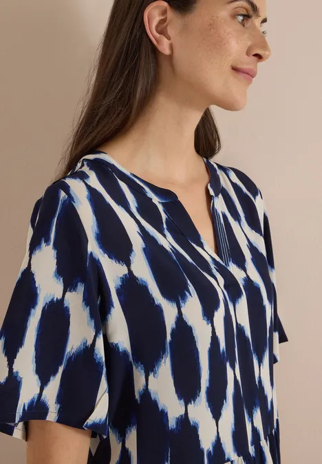 Knielanges Kleid mit Split Neck und Struktur urban dark blue Frau mit blau-weiß gemusterter Kurzarm-Bluse und V-Ausschnitt.