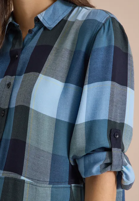 Kniehoge jurk met ruitjespatroon urban dark blue Naheinstellung eines karierten Hemdblusenshirts in Blautönen mit hochgekrempelten Ärmeln.