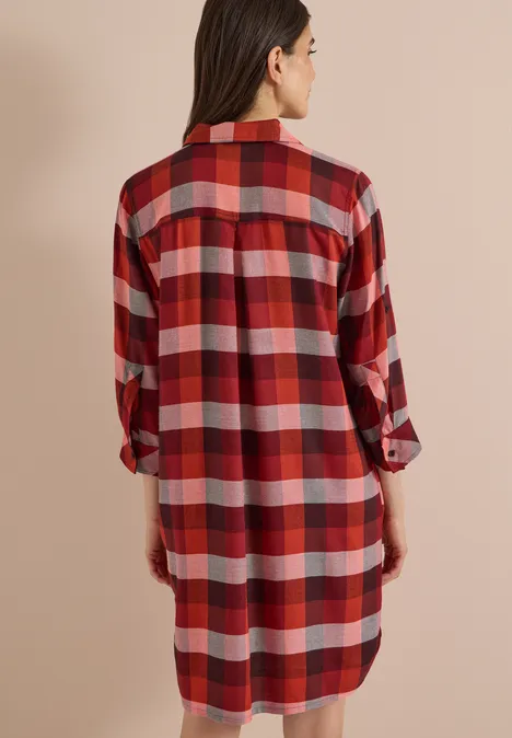 Kniehoge jurk met ruitjespatroon raw chocolate brown Frau von hinten in einem rot-weiß karierten, langen Hemdkleid mit zurückgeschlagenen Ärmeln.