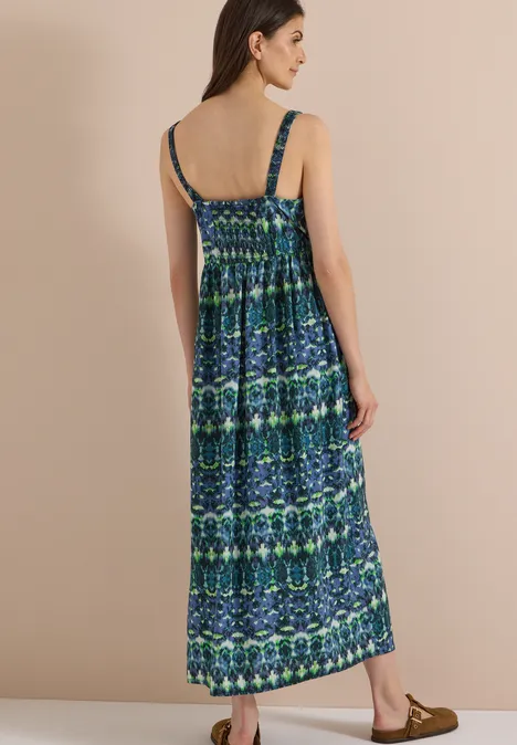 Maxikleid mit V-Neck und Print urban dark blue Frau im blauen, gemusterten Maxikleid mit Spaghettiträgern, von hinten vor neutralem Hintergrund.