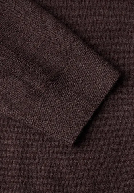 Nahaufnahme eines braunen Strickpullovers mit feiner Maschenstruktur.