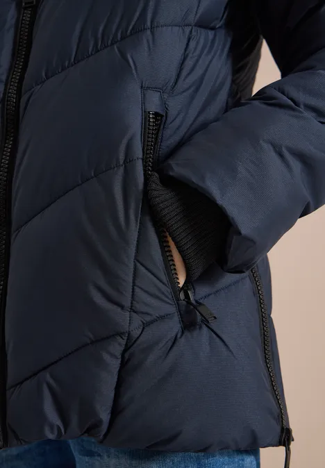 Dunkelblaue, gesteppt gepolsterte Jacke mit Reißverschluss, seitlicher Tasche und elastischem Ärmelbündchen.