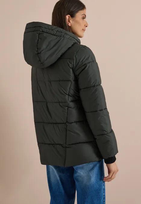 Puffer-Jacke in Midi-Länge mit Kapuze olive night Frau trägt schwarze gesteppte Daunenjacke mit Kapuze, von hinten gesehen.