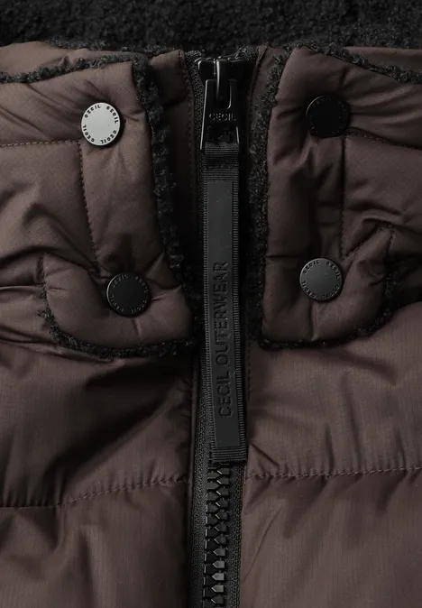 Nahaufnahme einer braunen Daunenjacke mit Reißverschluss und Druckknöpfen am Kragen.