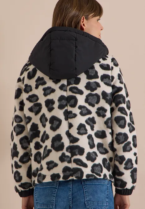 Jacke mit Wollanteil und Leo-Muster Black Frau von hinten in Leoprint-Fleecejacke mit schwarzer Kapuze und Jeans.