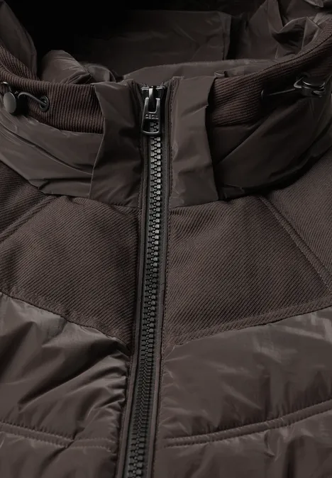 Veste matelassée à capuche avec des détails en sergé chocolate sauce brown Veste marron avec fermeture éclair centrale et motif matelassé, gros plan sur le haut.