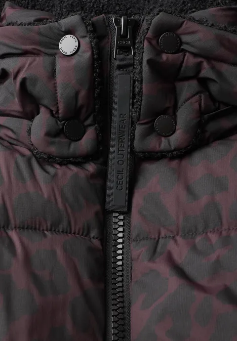Close-up van een doorgestikte jas met rits en donkerrood camouflagepatroon.