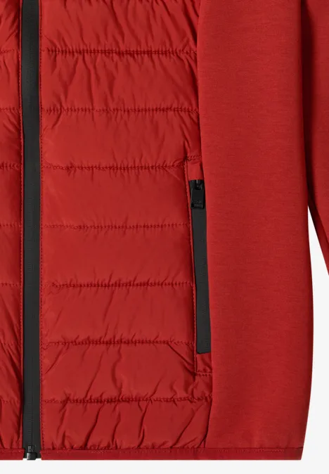 Nahaufnahme eines roten Jackets mit gestepptem, wattiertem Innenfutter und Reißverschlusstasche.