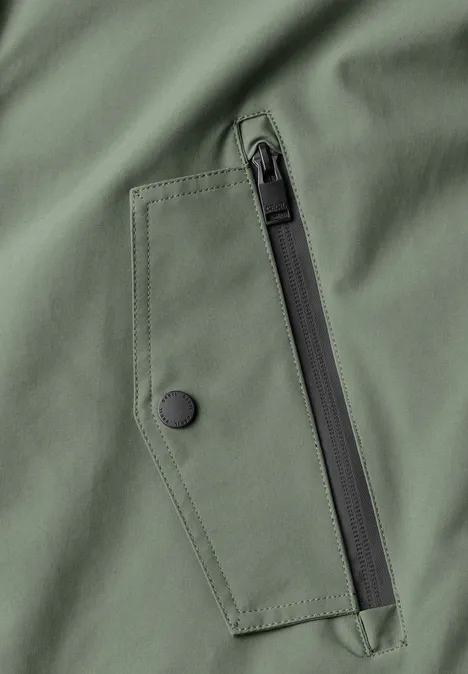 Kurze Jacke mit 2-in-1 Kapuze shadow khaki Nahaufnahme einer olivgrünen Jacke mit Reißverschluss- und Druckknopf-Tasche
