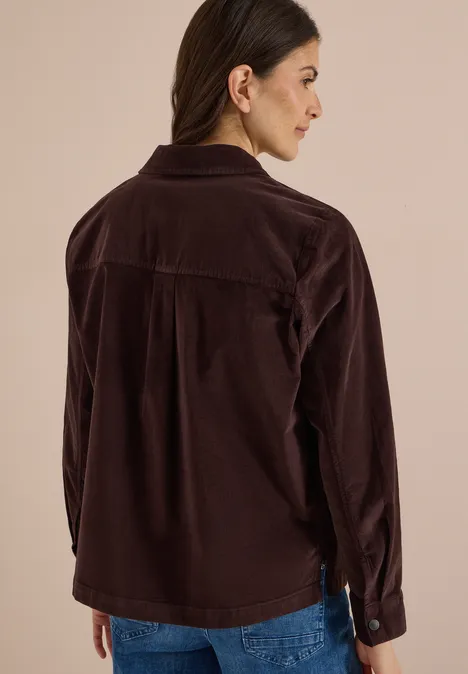 Femme de dos en veste en velours côtelé marron