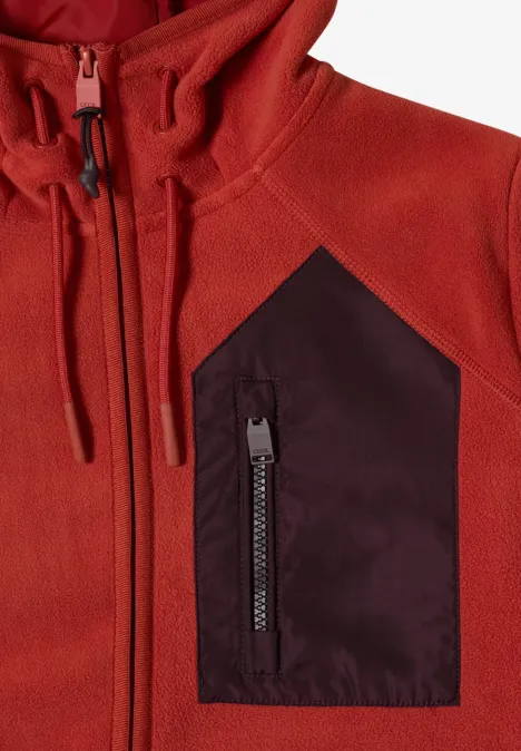 Rote Fleecejacke mit Kapuze und kontrastfarbener Brusttasche mit Reißverschluss.