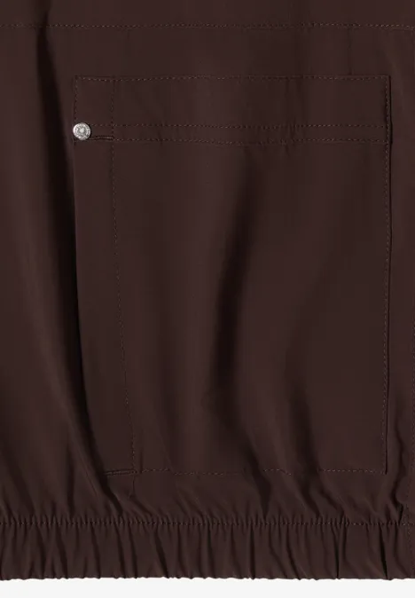 Blouson uni à fermeture zip brown cacao Tissu lisse marron foncé, poche latérale pressionnée et ourlet élastique d'un vêtement.