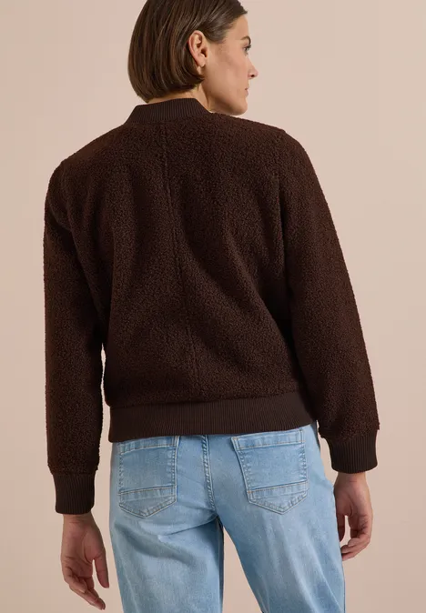 Blouson in Woll-Optik mit Zipper chocolate sauce brown Frau von hinten in brauner Teddyjacke und hellblauen Jeans, kurze Haare.