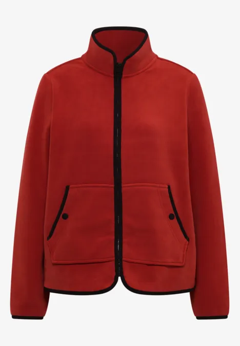 Rode fleece jas met opstaande kraag, ritssluiting voor en zwarte biezen bij mouwen en zakken.