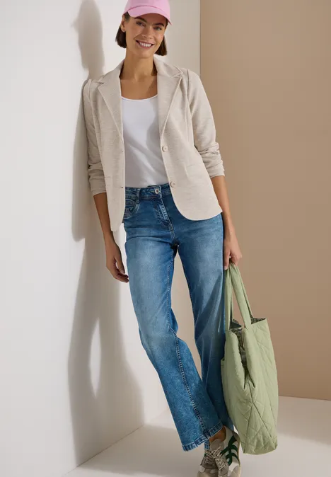 Blazer texturé, couleur unie cashmere beige melange Person in Jeans, weißem T-Shirt, hellem Blazer und großer grüner Tasche lehnt an Wand