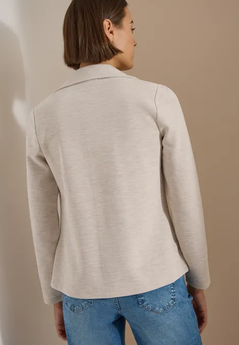 Blazer texturé, couleur unie cashmere beige melange Eine Frau von hinten in beiger Jacke und Jeans vor neutralem Hintergrund.