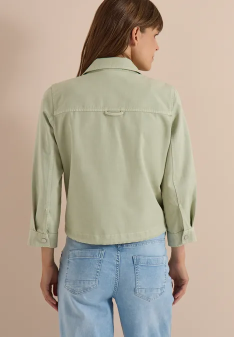 Frau von hinten in hellgrüner Cordjacke und blauen Jeans.