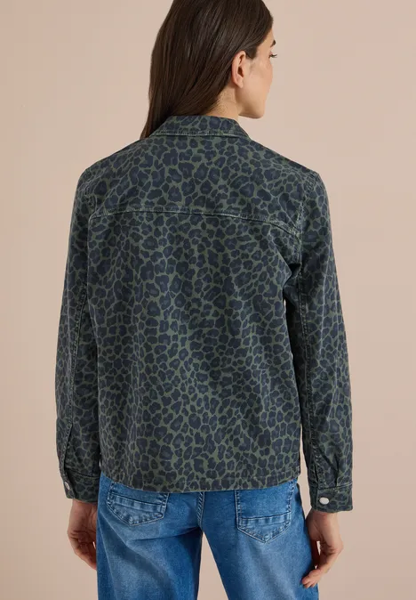 Denim Overshirt mit Leo-Muster dried olive green Frau von hinten in blau-grün gemusterter Jeansjacke vor beigem Hintergrund.