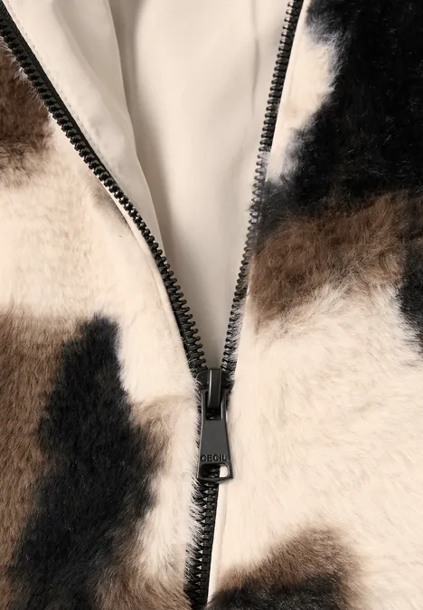 Fake Fur Blouson mit Kuhmuster pearl beige Nahaufnahme eines flauschigen Kunstfellmantels in Kuhmuster mit schwarzem Reißverschluss.