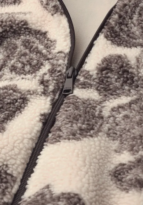 Nahaufnahme eines grauen und weißen Fleece-Stoffes mit Reißverschluss in der Mitte.