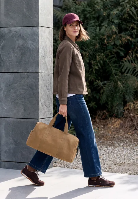 Denim Overshirt mit Brusttaschen truffle brown Frau mit roter Kappe, brauner Jacke und blauer Jeans trägt eine große hellbraune Tasche beim Spaziergang.