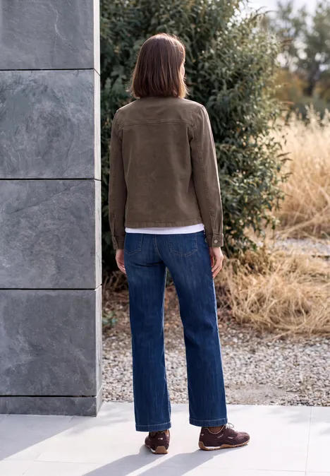 Denim Overshirt mit Brusttaschen truffle brown Eine Person steht mit dem Rücken zur Kamera in Outdoor-Umgebung, trägt braune Jacke, Jeans und braune Schuhe.