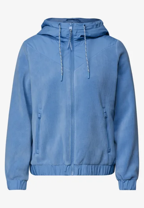 Lichtblauwe capuchonjas met ritssluiting, elastische zoom en zijzakken.