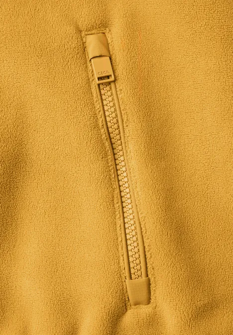 Fleecejas met capuchon en softshell-details golden honey Close-up van een mosterdgele fleecejas met ritssluiting.