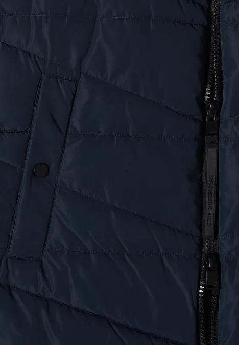 Veste matelassée bleu foncé avec fermeture éclair et poche à rabat bouton.